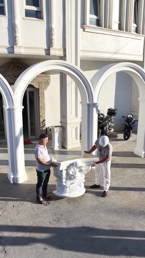 Completed exterior arches and decorative columns frame a grand entrance.