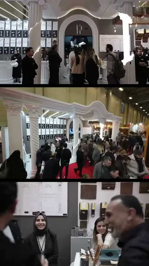 Vista panoramica dell'ingresso colonnato dello stand e del flusso intenso di visitatori