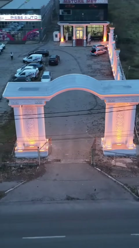 Wavy arch form framing the road entrance over ornamental supporting pillars