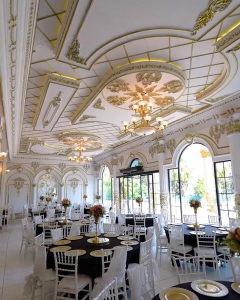 Wedding hall ceiling with gold ornate molding and crystal chandeliers