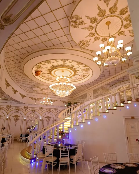 Grand staircase hall with ornate ceiling and purple accent lighting