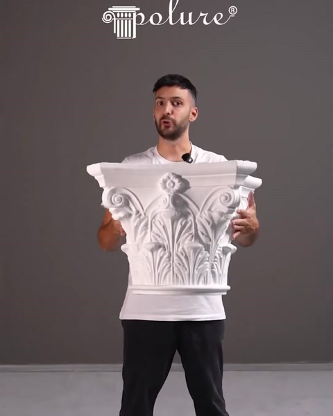 Presenter holding a carved decorative column capital piece