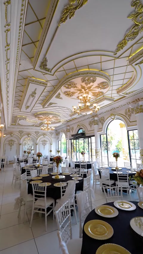 Wedding hall ceiling with gold ornate molding and crystal chandeliers