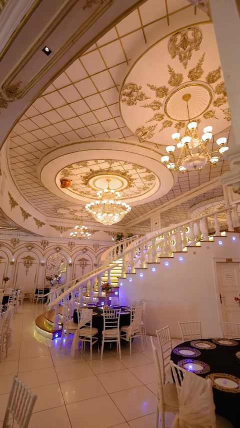 Grand staircase hall with ornate ceiling and purple accent lighting