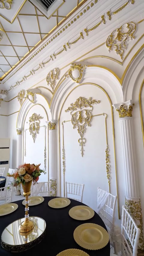 Wall panel with gold-trimmed decorative molding and floral vase