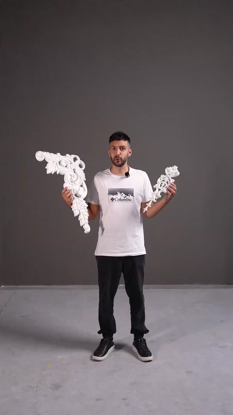 Presenter holding white decorative openwork architrave pieces in hands