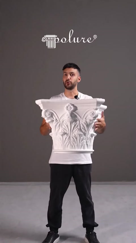 Presenter holding a carved decorative column capital piece