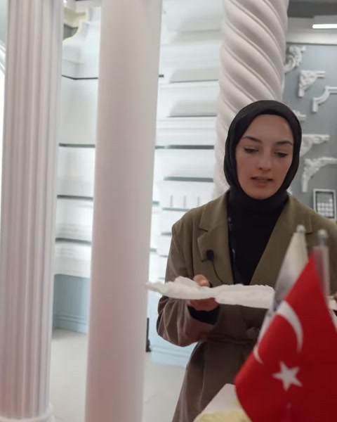 Il profilo di un sottile elemento decorativo bianco viene mostrato accanto a un tavolo