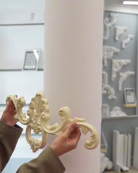 Un elemento decorativo curvo viene posizionato a mano sulla superficie della colonna rotonda