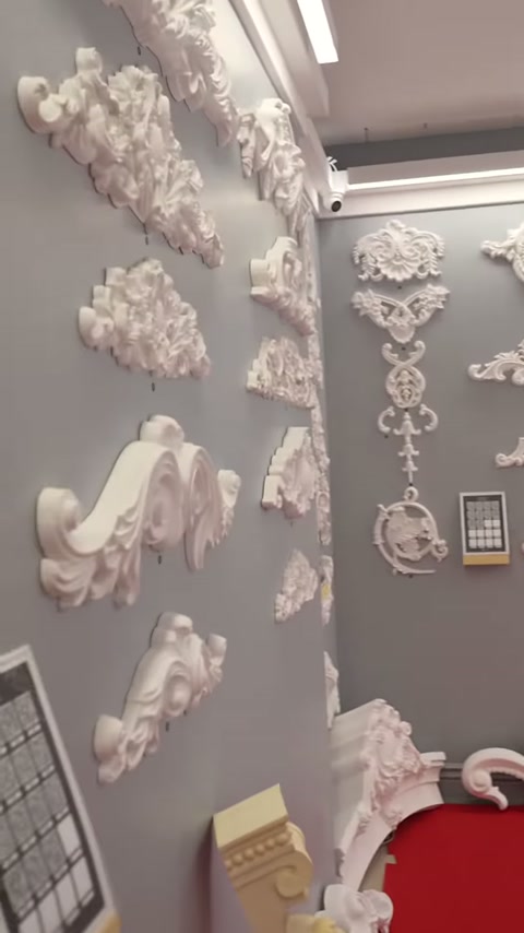 Un grande esempio di bordura curvilinea bianca viene esposto insieme a parti decorative murali