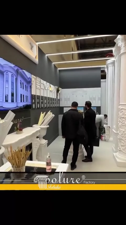 Pannelli murali, campioni di modanature e colonne decorative lungo il corridoio dello stand
