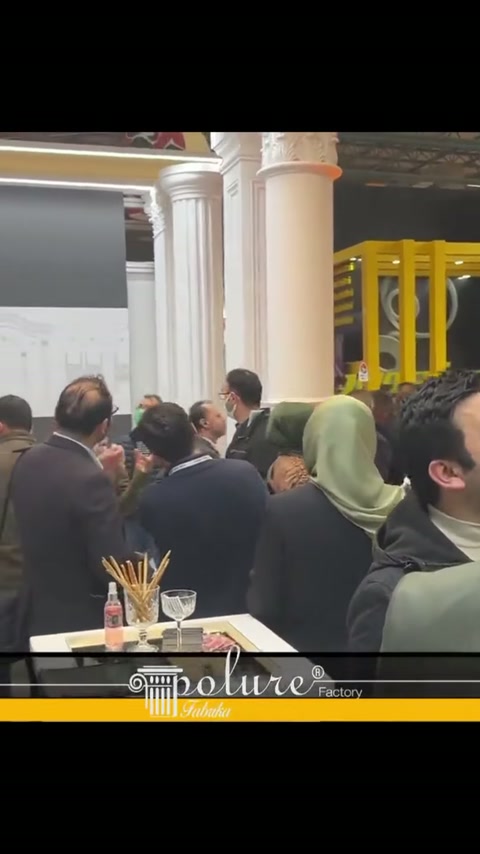 Folto gruppo di visitatori di fronte alla fila di colonne classiche esamina i prodotti