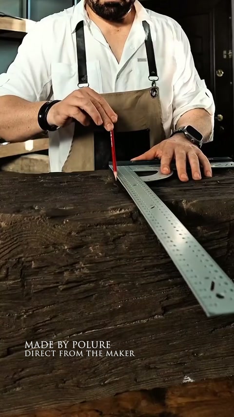 Un artigiano misura una trave decorativa prima del taglio o dell’adattamento.