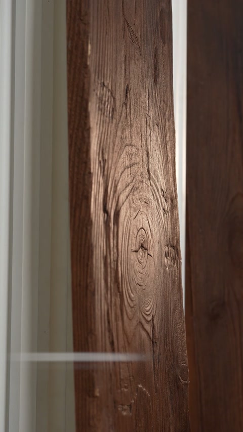 Una colonna decorativa verticale mostra una texture continua di venature del legno scolpite.