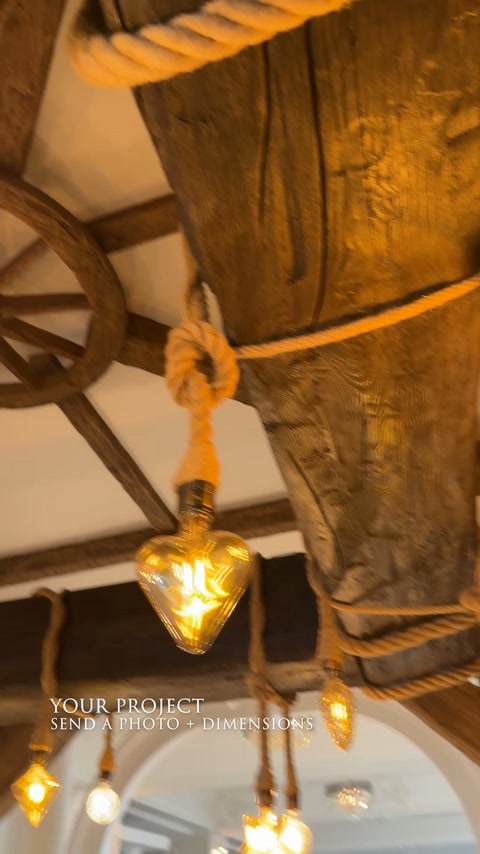 L’illuminazione sospesa con corde si trova sotto ampie travi rustiche del soffitto.