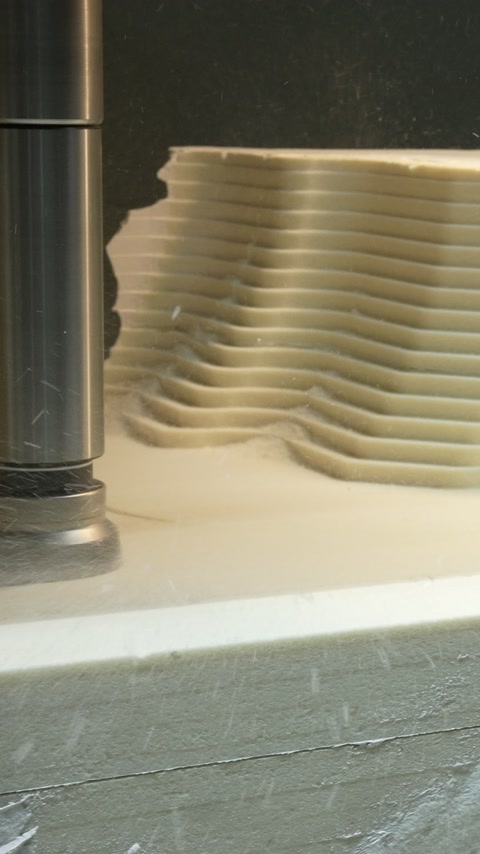 Router shapes a layered polyurethane profile during workshop production.