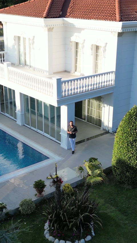 Aerial view shows the completed villa facade and balustraded terrace.