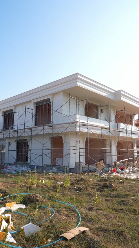 Scaffolding surrounds the facade during installation of exterior mouldings.