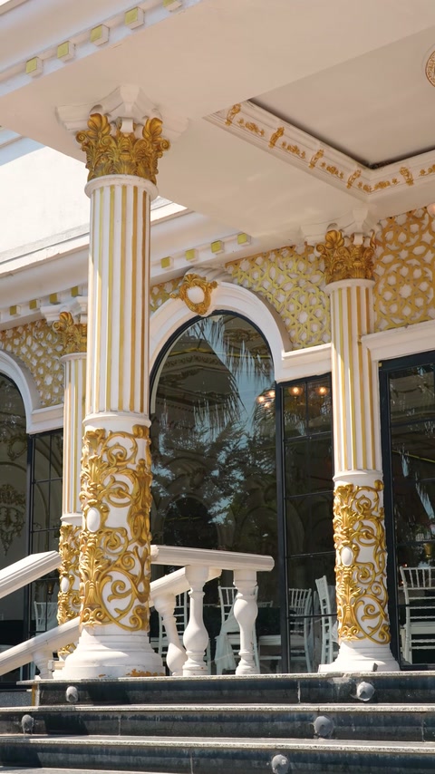 Fluted columns with gilded capitals frame the main arched doorway.