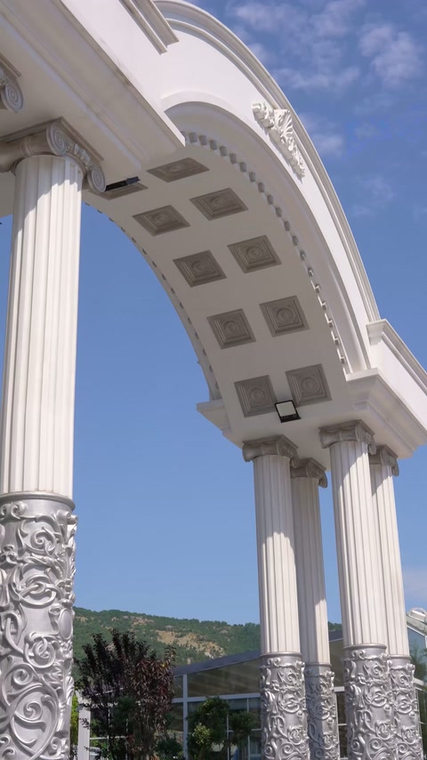 Curved entrance arch reveals coffered detailing and a decorated column.