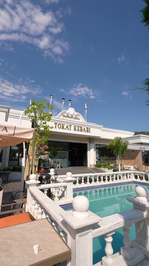 Decorative balustrades and cornices unify the poolside venue facade.