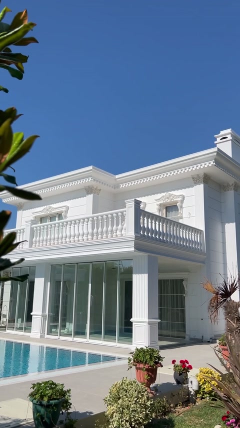 White facade combines balcony balusters, window surrounds, and roof cornices.