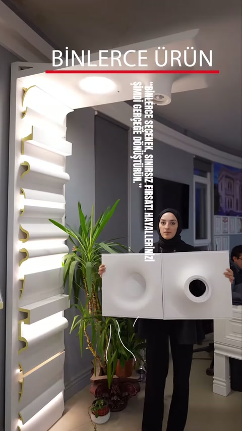 Pannelli di rosoni bianchi con motivi circolari al soffitto vengono presentati nell'area espositiva