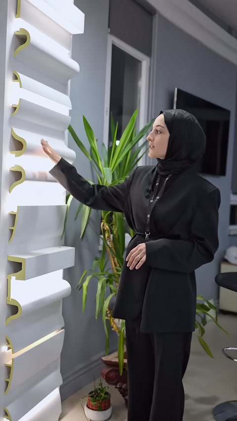 Il venditore indica le opzioni di cornice in poliuretano con illuminazione nascosta sulla parete della showroom.