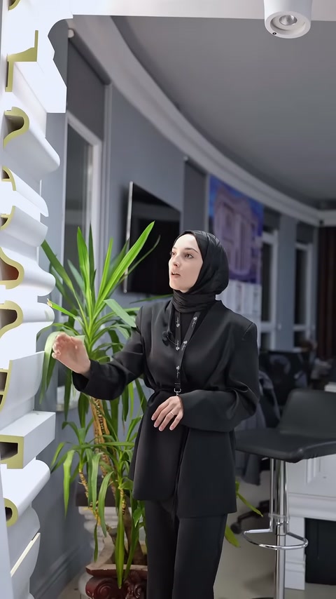 Sezioni di cornice bianca e il venditore sono visibili nell'angolo illuminato della showroom.