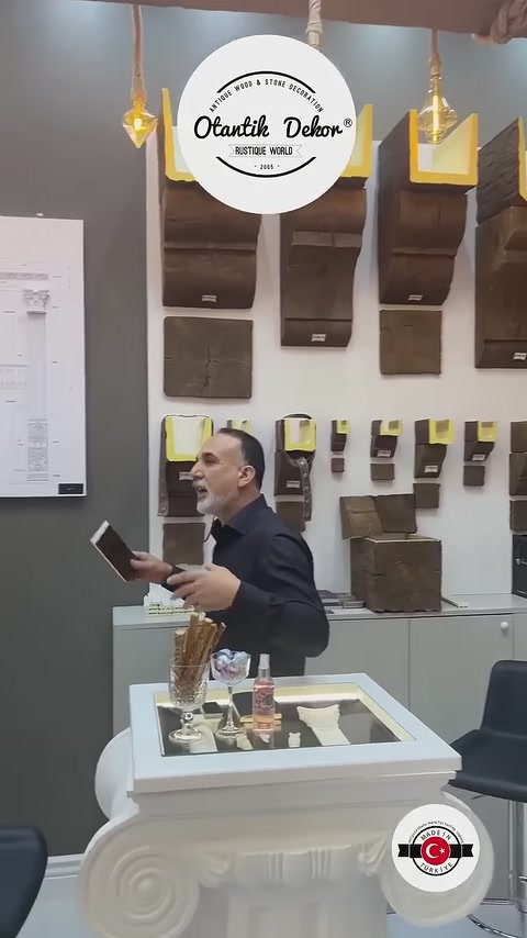 Sezioni di travi marroni e campioni di superficie ricoprono la parete espositiva