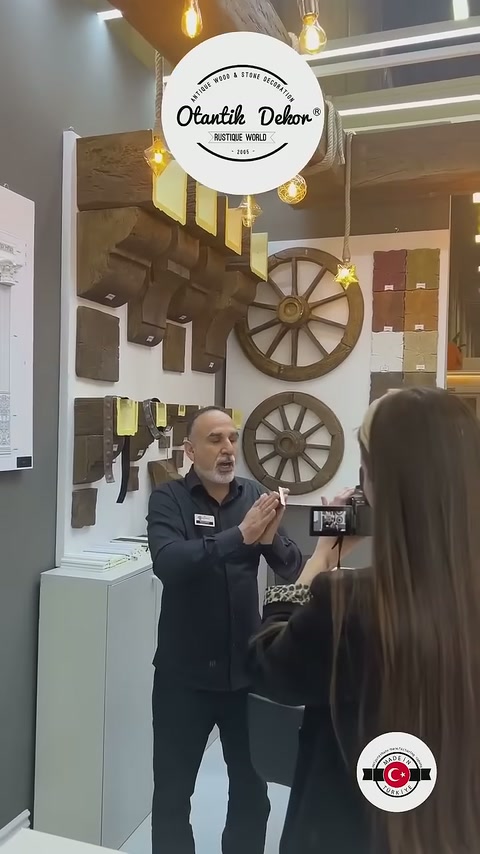 L'addetto presenta esempi di travi in tonalità scura nell'area espositiva al visitatore