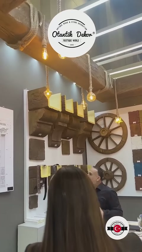 L'addetto indica con la mano diversi segmenti di travi sullo stand murale