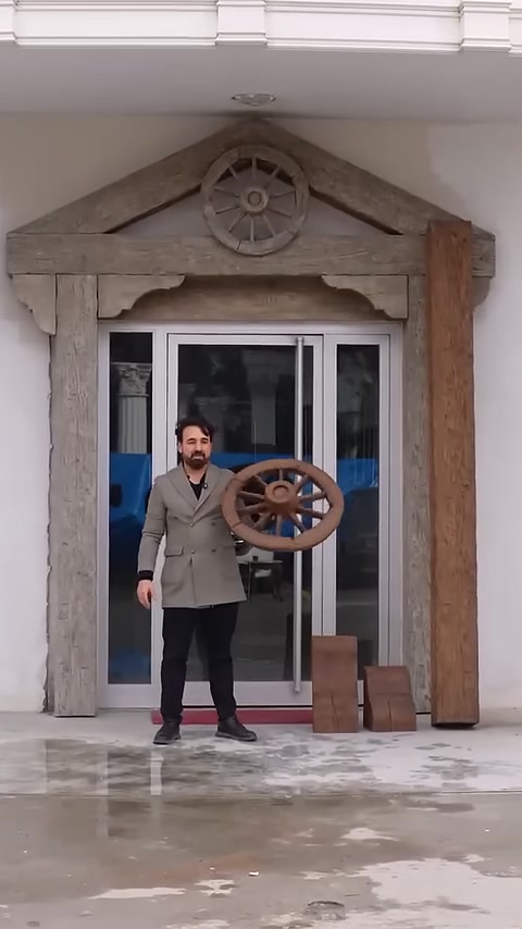 Una ruota decorativa effetto legno è esposta davanti all'applicazione dell'ingresso rustico