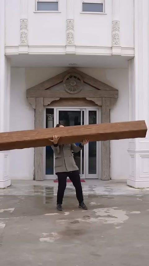 Una trave dall'aspetto legnoso viene sollevata davanti alla porta d'ingresso.