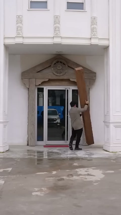 Il maestro sostiene una sezione di trave verticale sul lato destro della porta.