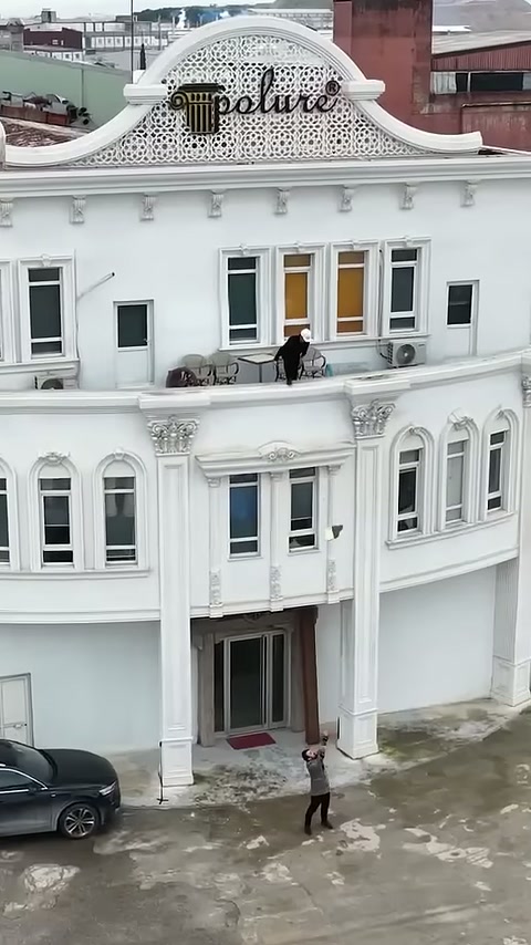 La sezione di trave viene abbassata verso l'ingresso davanti alla facciata bianca.