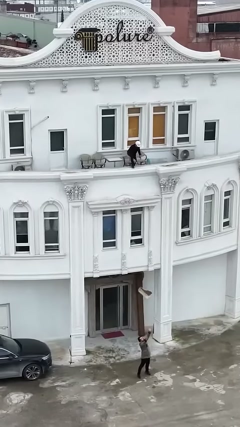 Il maestro sottostante afferra il pezzo decorativo che scende dalla terrazza.