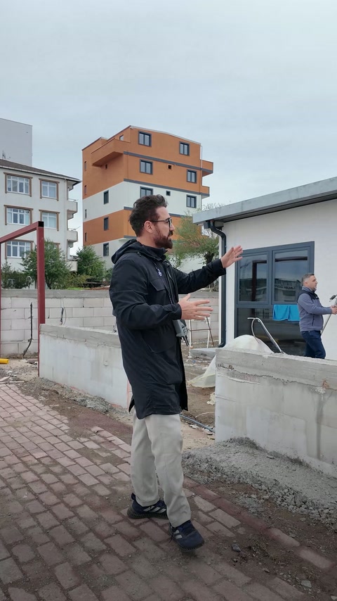 Il presentatore spiega il rilievo esterno vicino alle finestre e ai muri di confine.