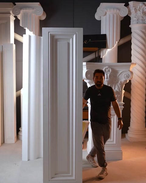 Man walking past tall door architrave panel in factory setting
