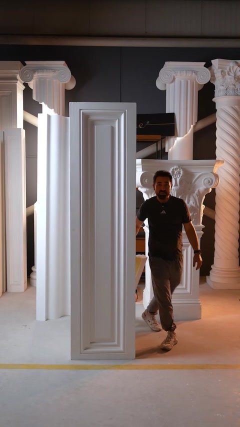 Uomo che cammina davanti a un alto pannello di architrave per porta in ambiente industriale
