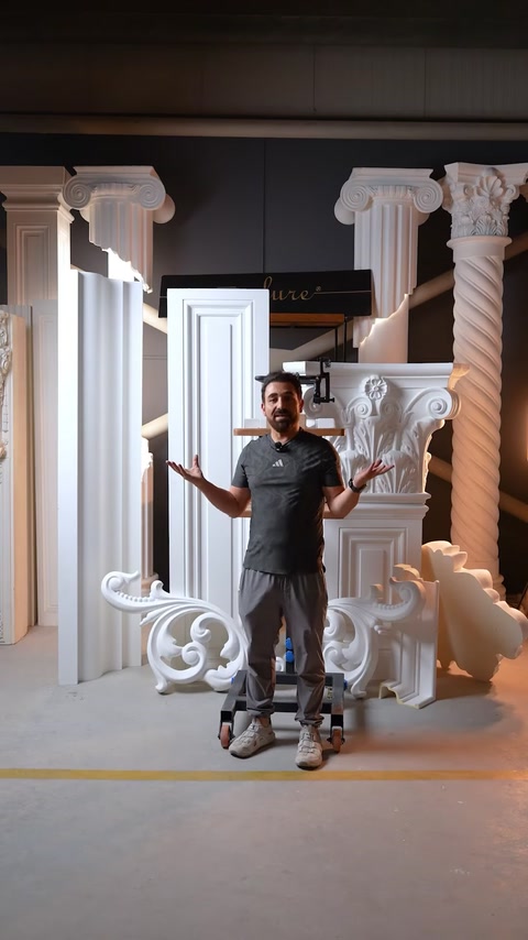Uomo che presenta un capitello finito con assemblaggio di applique a voluta