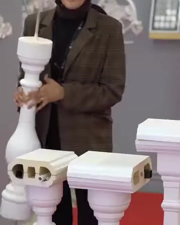 Il presentatore mostra verticalmente un modello classico di balaustro bianco in poliuretano.