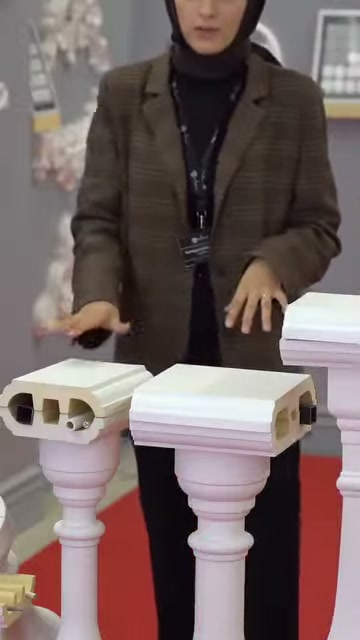 Il presentatore mostra con la mano la superficie del profilo di cornicione a copertura larga.