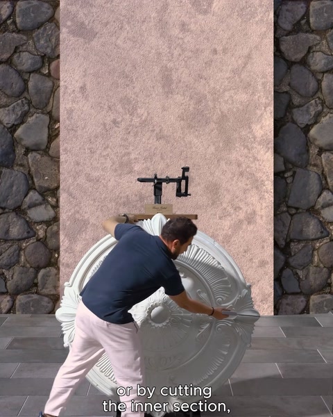 Operaio che taglia la parte interna di un rosone bianco per l'installazione a parete