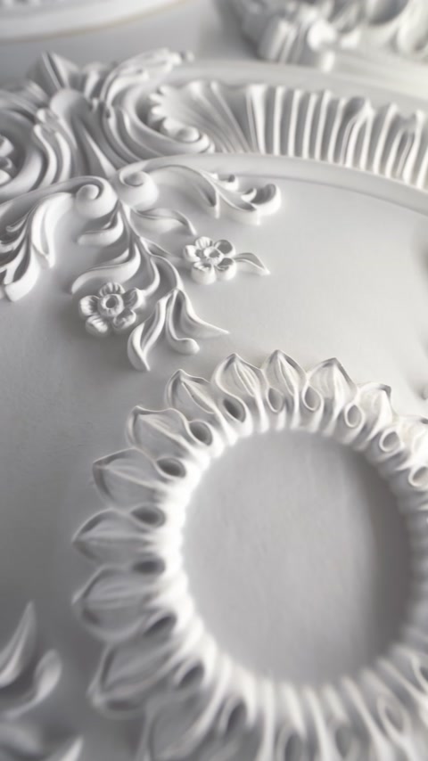 Close-up of carved floral petal detail on white ceiling medallion