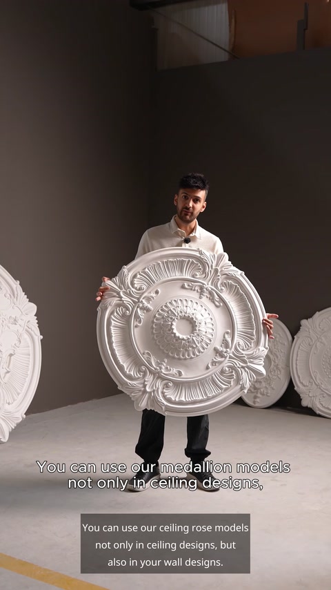 Man holding round white ceiling medallion in showroom with stacked models
