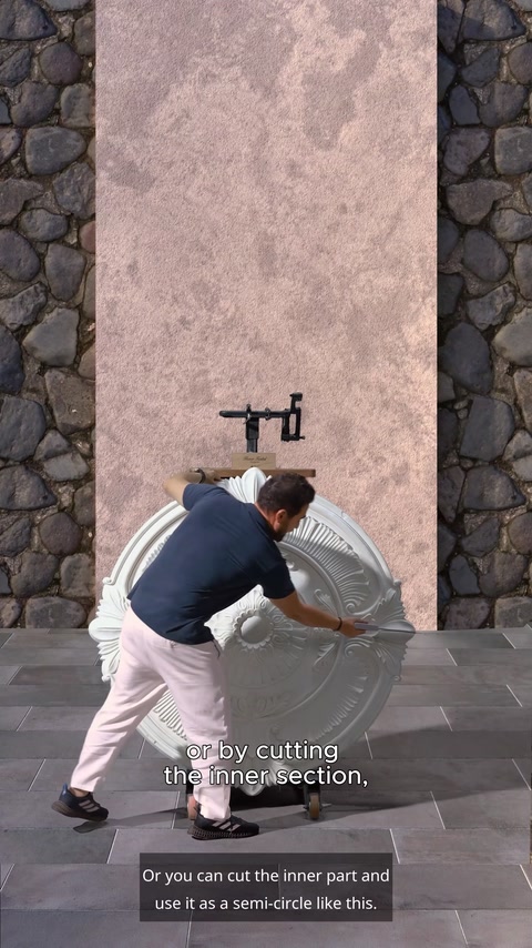 Worker cutting inner section of white medallion for wall installation