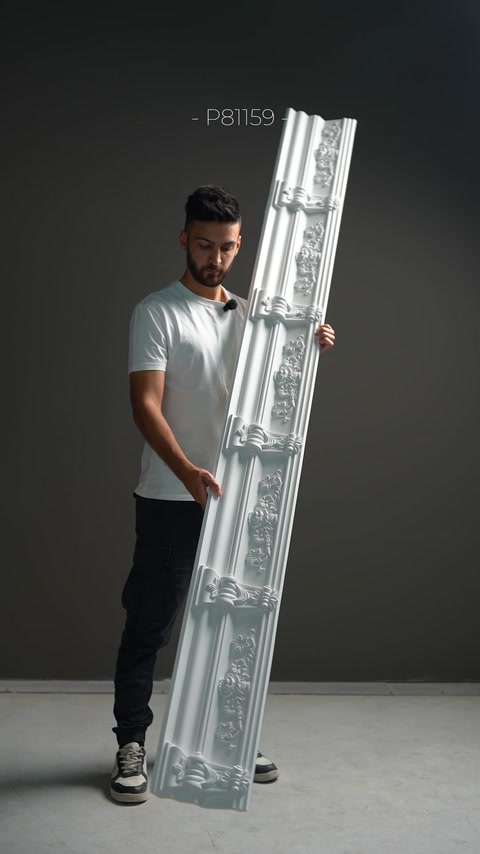 Un modello di cornice con ricchi rilievi classici viene esposto in verticale.