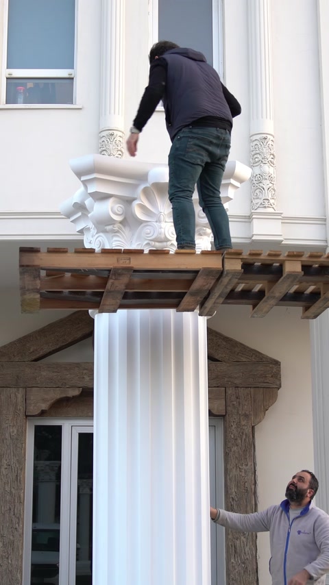 Un capitello ornato è montato sopra una colonna scanalata finita.
