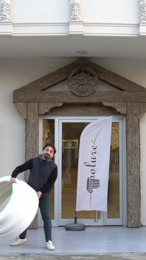 Un operaio gestisce un componente di colonna circolare all'ingresso dell'edificio.